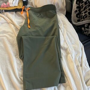 Figs technical collection size large , green with orange tie at waist .